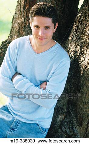 Stock Photo - guy relaxed against a tree. Fotosearch
