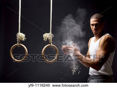 Gymnast man powdering hands on rings. View Large Photo Image Stock Photography - Gymnast man powdering hands on rings.. Fotosearch