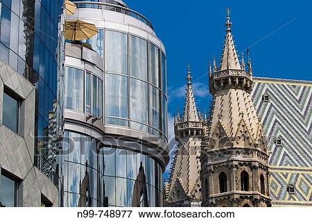 Stock Photo - Haas House and St. Stephens Cathedral, modern architecture, reflections, gothic style cathedral, Vienna, Austria. Fotosearch