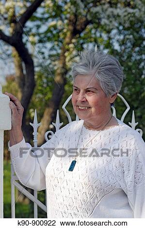 Half body image of elderly caucasian woman wearing a white sweater at sunny weather, looking friendly and with a blossoming tree in the background, Island of Amrum, Northfrisian, Schleswig_Holstein, Northern Germany, Europe View Large Photo Image Stock Image - Half body image of elderly caucasian woman wearing a white sweater at sunny weather, looking friendly and with a blossoming tree in the background, Island of Amrum, Northfrisian, Schleswig_Holstein, Northern Germany, Europe. Fotosearch