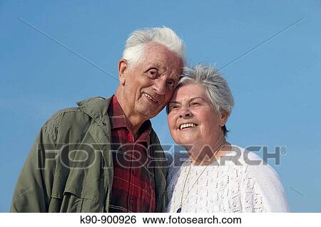 Half body image of elderly caucasian couple smiling and looking into the camera with bright blue sky in the background, Island of Amrum, Northfrisian, Schleswig_Holstein, Northern Germany, Europe View Large Photo Image Stock Photograph - Half body image of elderly caucasian couple smiling and looking into the camera with bright blue sky in the background, Island of Amrum, Northfrisian, Schleswig_Holstein, Northern Germany, Europe. Fotosearch