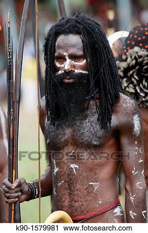 Half body image of local, nacked Papuan man, lwith traditional body painting and long hair, holding his bow and arrows, Baliem Valley festival, Jayawijaya region, Papua, Indonesia, Southeast Asian View Large Photo Image Stock Image - Half body image of local, nacked Papuan man, lwith traditional body painting and long hair, holding his bow and arrows, Baliem Valley festival, Jayawijaya region, Papua, Indonesia, Southeast Asian. Fotosearch