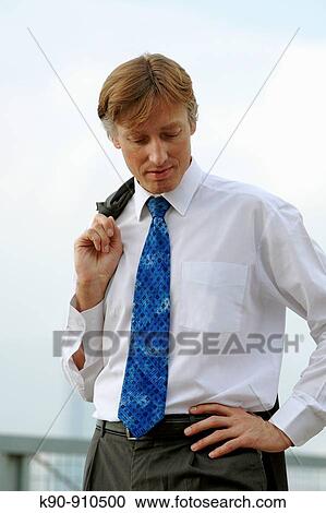 Half body photograph of young, caucasian business man in white shirt, wearing his suit jacket over the shoulder and looking thoughtful down, Hong Kong, China, Asia View Large Photo Image Stock Image - Half body photograph of young, caucasian business man in white shirt, wearing his suit jacket over the shoulder and looking thoughtful down, Hong Kong, China, Asia. Fotosearch