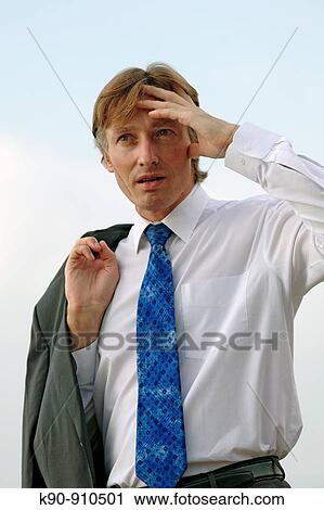 Half body photograph of young, caucasian business man in white shirt, wearing his suit jacket over the shoulder and looking into the far distance while holding one hand as shield over his eyes, Hong Kong, China, Asia View Large Photo Image Stock Image - Half body photograph of young, caucasian business man in white shirt, wearing his suit jacket over the shoulder and looking into the far distance while holding one hand as shield over his eyes, Hong Kong, China, Asia. Fotosearch