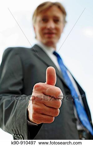 Half body photograph of young, caucasian business man in suit and tie, with thumbs-up sign, face blurred, Hong Kong, China, Asia View Large Photo Image Stock Photo - Half body photograph of young, caucasian business man in suit and tie, with thumbs-up sign, face blurred, Hong Kong, China, Asia. Fotosearch