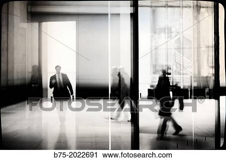 Stock Image - Hall of an office building with a several unrecognizable executives, City, London, England, UK. Fotosearch