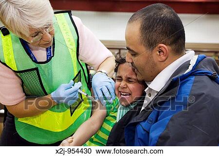 Hamtramck, Michigan - A health care worker vaccinates a girl against the H1N1 swine flu View Large Photo Image Stock Image - Hamtramck, Michigan - A health care worker vaccinates a girl against the H1N1 swine flu. Fotosearch