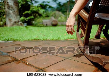 Stock Photo - Hand and arm from woman sitting in a rocking chair, overlooking Losari Coffee Plantation in West Java, Indonesia, South East Asia. Fotosearch