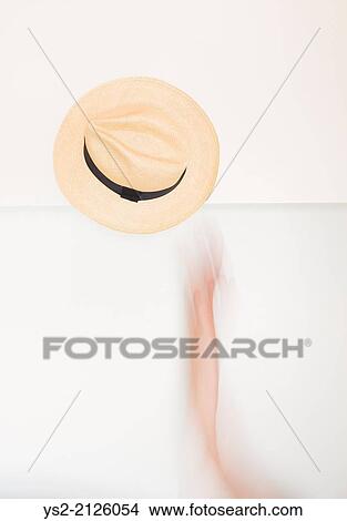 Hand and arm in movement throwing a Panama hat in the air. Conceptual image of expressing happiness, joy and excitement. View Large Photo Image Picture - Hand and arm in movement throwing a Panama hat in the air. Conceptual image of expressing happiness, joy and excitement.. Fotosearch