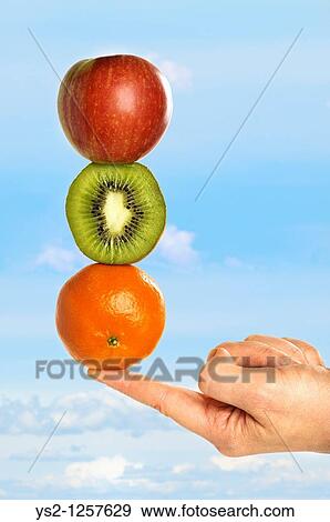 Hand balancing fruits on fingertip View Large Photo Image Stock Photo - Hand balancing fruits on fingertip. Fotosearch