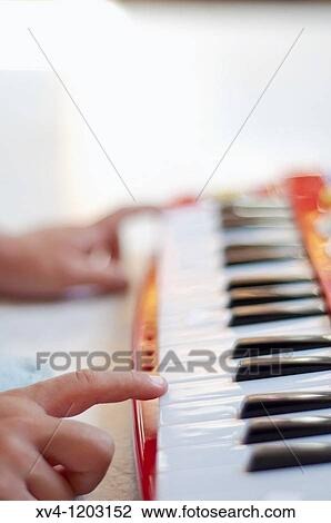 Stock Image - Hand boy playing electronic piano. Fotosearch