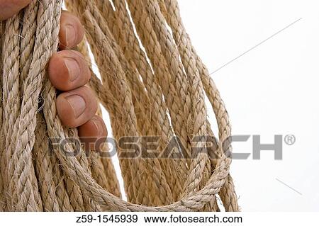 Stock Photo - hand clutching natural colored rope. Fotosearch