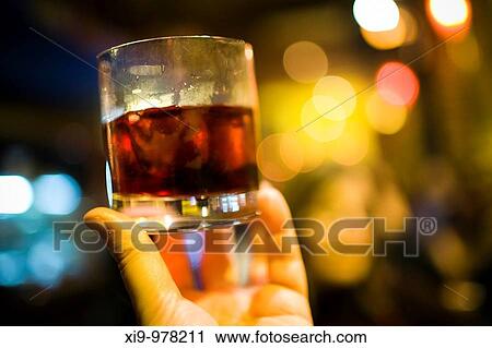 Hand holding a glass with alcoholic beverage, Seville, Spain View Large Photo Image Stock Image - Hand holding a glass with alcoholic beverage, Seville, Spain. Fotosearch
