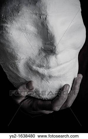Stock Image - Hand holding a smiling mask. Fotosearch