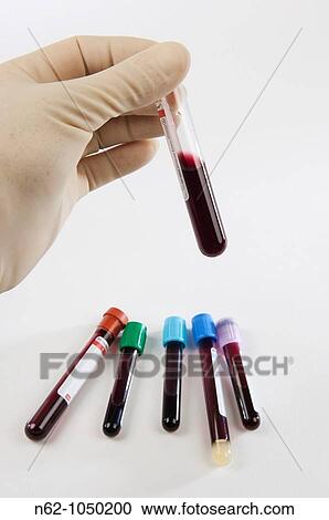 Hand holding a tube between the fingers and the other on a white table View Large Photo Image Stock Image - Hand holding a tube between the fingers and the other on a white table. Fotosearch