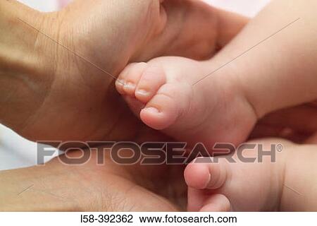Hand holding feet of newborn baby View Large Photo Image Stock Image - Hand holding feet of newborn baby. Fotosearch