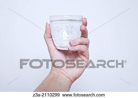 Stock Photo - Hand Holding Glass Of Water, Hand Gesture, Studio shot. Fotosearch