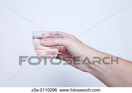 Stock Photograph - Hand Holding Glass Of Water, Hand Gesture, Studio shot. Fotosearch