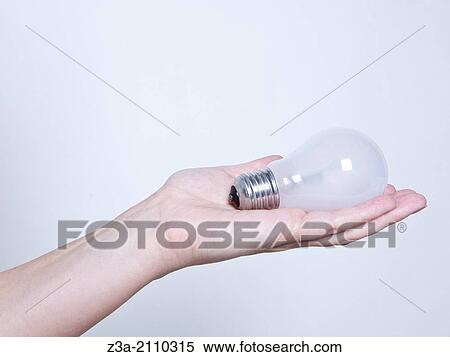 Stock Photography - Hand Holding Lightbulb, Hand Gesture, Studio shot. Fotosearch