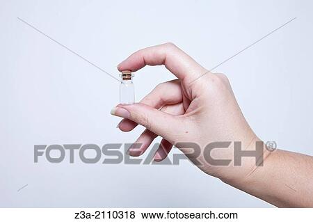 Hand Holding Little Glass Bottle, Hand Gesture, Studio shot View Large Photo Image Stock Photo - Hand Holding Little Glass Bottle, Hand Gesture, Studio shot. Fotosearch