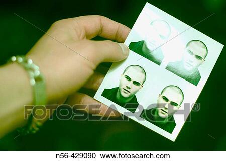 Stock Image - Hand holding photographs.. Fotosearch