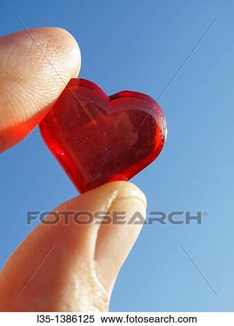 Hand holding small glass heart with blue sky View Large Photo Image Stock Photography - Hand holding small glass heart with blue sky. Fotosearch