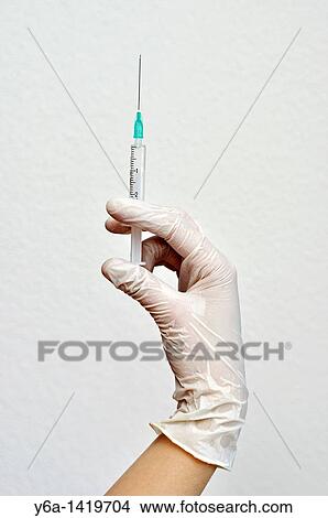 Hand holding syringe View Large Photo Image Picture - Hand holding syringe. Fotosearch