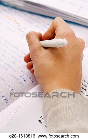 Hand of teenage girl writing and doing her homework in a copybook View Large Photo Image Stock Photograph - Hand of teenage girl writing and doing her homework in a copybook. Fotosearch