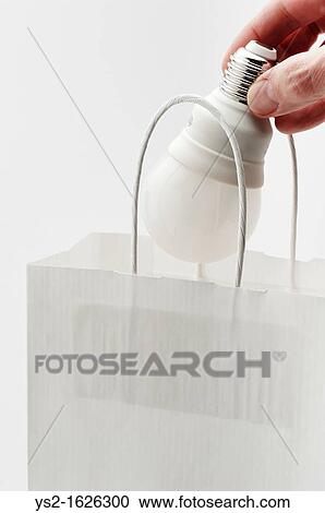 Hand placing energy efficient lightbulb in paper bag View Large Photo Image Stock Image - Hand placing energy efficient lightbulb in paper bag. Fotosearch