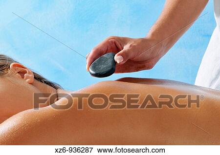 Hand placing hot stone for therapy View Large Photo Image Stock Photo - Hand placing hot stone for therapy. Fotosearch