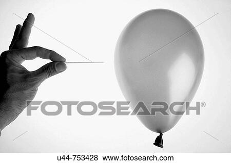 Hand stings a balloon with a needle View Large Photo Image Stock Photo - Hand stings a balloon with a needle. Fotosearch