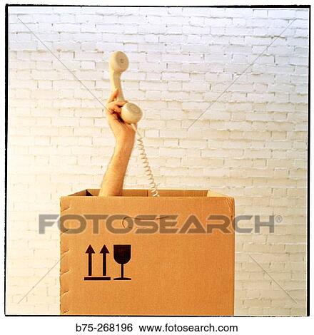 Hand with telephone from inside a cardboard box View Large Photo Image Stock Photograph - Hand with telephone from inside a cardboard box. Fotosearch