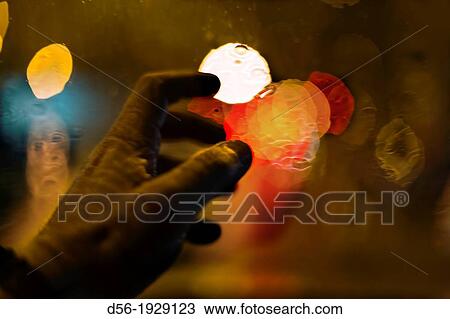 Stock Image - Hands inside of a car in a rainy day. Fotosearch