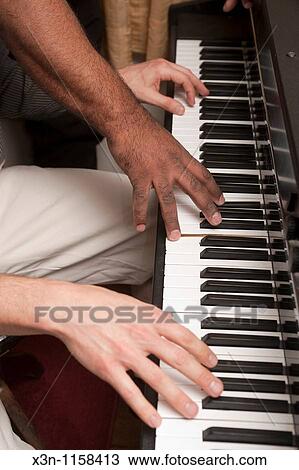 Hands on a piano keyboard View Large Photo Image Stock Image - Hands on a piano keyboard. Fotosearch