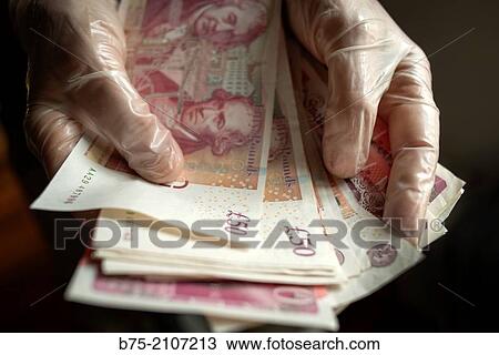 Hands with plastic gloves holding 50 pounds notes of english currency. England, UK. View Large Photo Image Stock Image - Hands with plastic gloves holding 50 pounds notes of english currency. England, UK.. Fotosearch