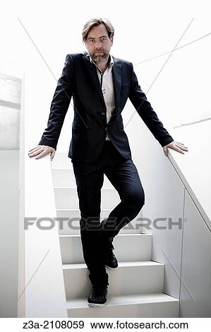 Handsome Business Man Standing on Stairs View Large Photo Image Stock Photo - Handsome Business Man Standing on Stairs. Fotosearch