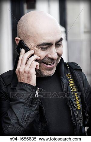 Handsome man, bald bearded, talking to the phone. View Large Photo Image Stock Photography - Handsome man, bald bearded, talking to the phone.. Fotosearch