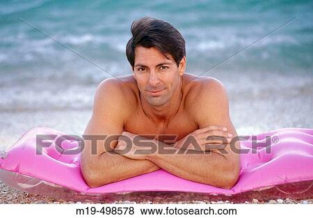 handsome man lying on the beach View Large Photo Image Stock Photo - handsome man lying on the beach. Fotosearch