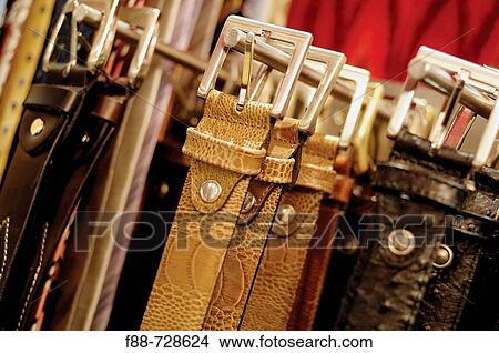 Picture - Hanged leather belts, clothes, still life. Fotosearch