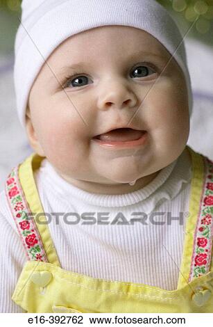 Stock Image - happy baby girl with white cap. Fotosearch