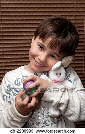 Happy boy age 8 holding his newly dyed Easter eggs and stuffed bunny. St Paul Minnesota MN USA. View Large Photo Image Stock Image - Happy boy age 8 holding his newly dyed Easter eggs and stuffed bunny. St Paul Minnesota MN USA.. Fotosearch