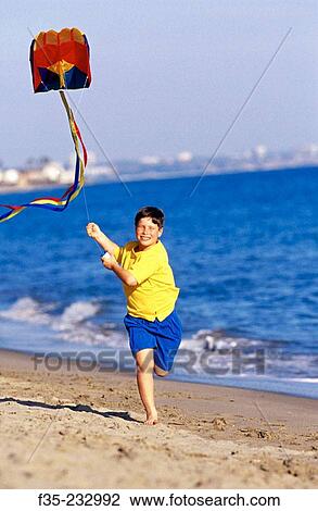 Happy boy running on beach with kite View Large Photo Image Stock Image - Happy boy running on beach with kite. Fotosearch