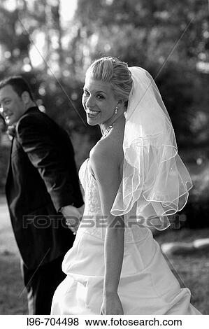 happy bride and groom looking back at guests before leaving the reception View Large Photo Image Stock Photo - happy bride and groom looking back at guests before leaving the reception. Fotosearch