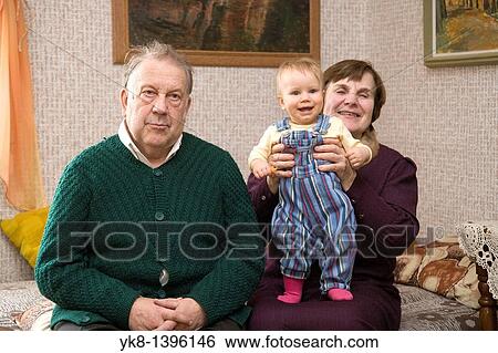 Stock Photograph - Happy Caucasian Senior Grandparents Holding Kid Baby. Fotosearch