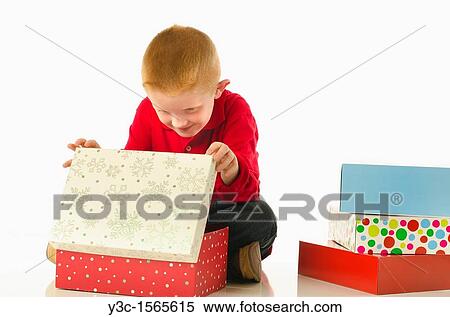 Stock Photography - Happy child at gift opening on Christmas Eve. Fotosearch
