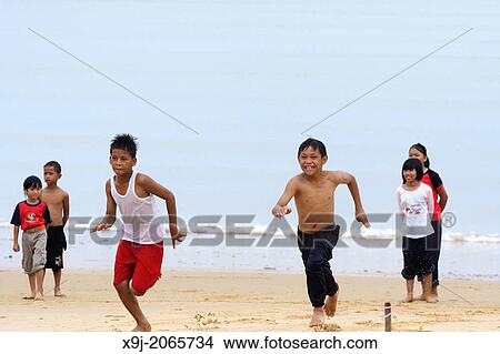 Picture - happy child group playing on beach, kuching, sarawak, malaysia, asia. Fotosearch