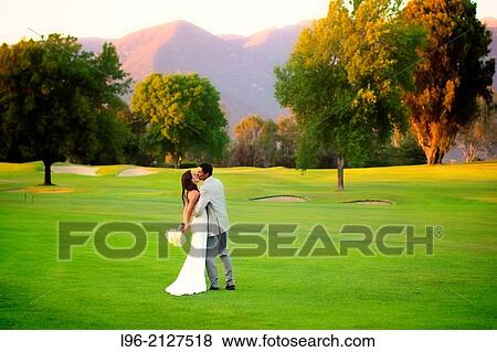 happy couple embracing after wedding ceremony, on a lush golf course / mountains setting View Large Photo Image Stock Photo - happy couple embracing after wedding ceremony, on a lush golf course / mountains setting. Fotosearch