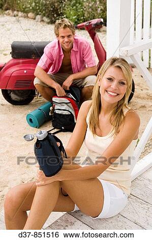 Happy couple having a break on a country trip with a scooter View Large Photo Image Stock Photograph - Happy couple having a break on a country trip with a scooter. Fotosearch