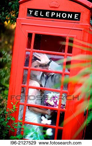 happy couple hiding out in an old red phone booth, enjoying a moment alone View Large Photo Image Stock Photo - happy couple hiding out in an old red phone booth, enjoying a moment alone. Fotosearch