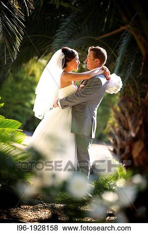 happy couple in an embrace in a private moment after their garden wedding ceremony View Large Photo Image Stock Photo - happy couple in an embrace in a private moment after their garden wedding ceremony. Fotosearch